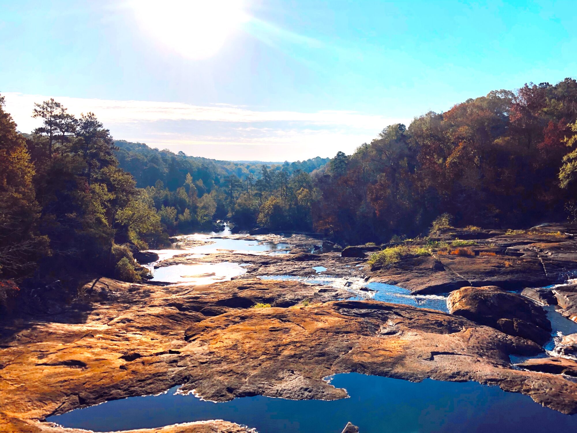 Camping site with river flowing over rocks and waterfall 