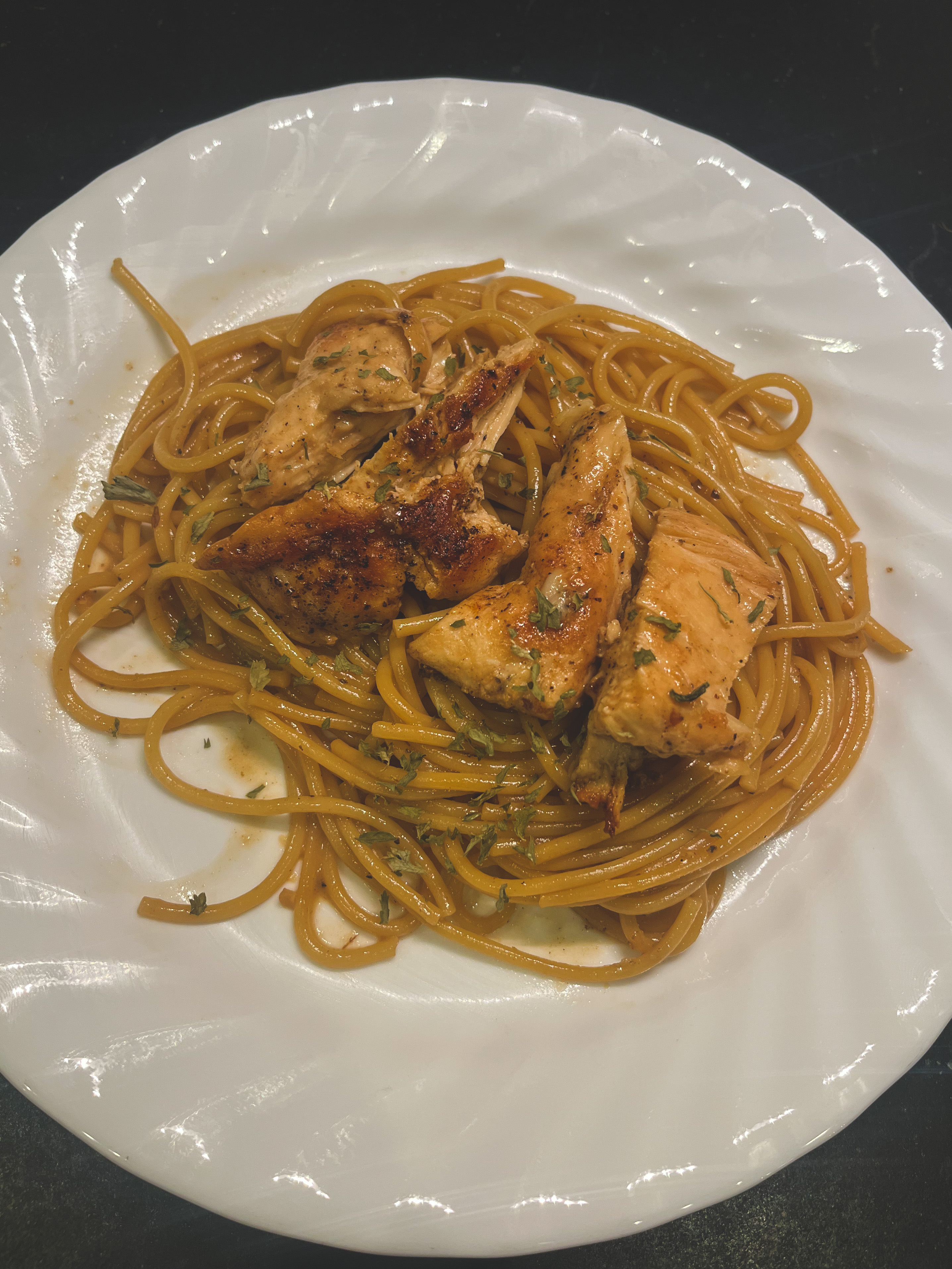 Pan seared chicken with pasta on a white dish 