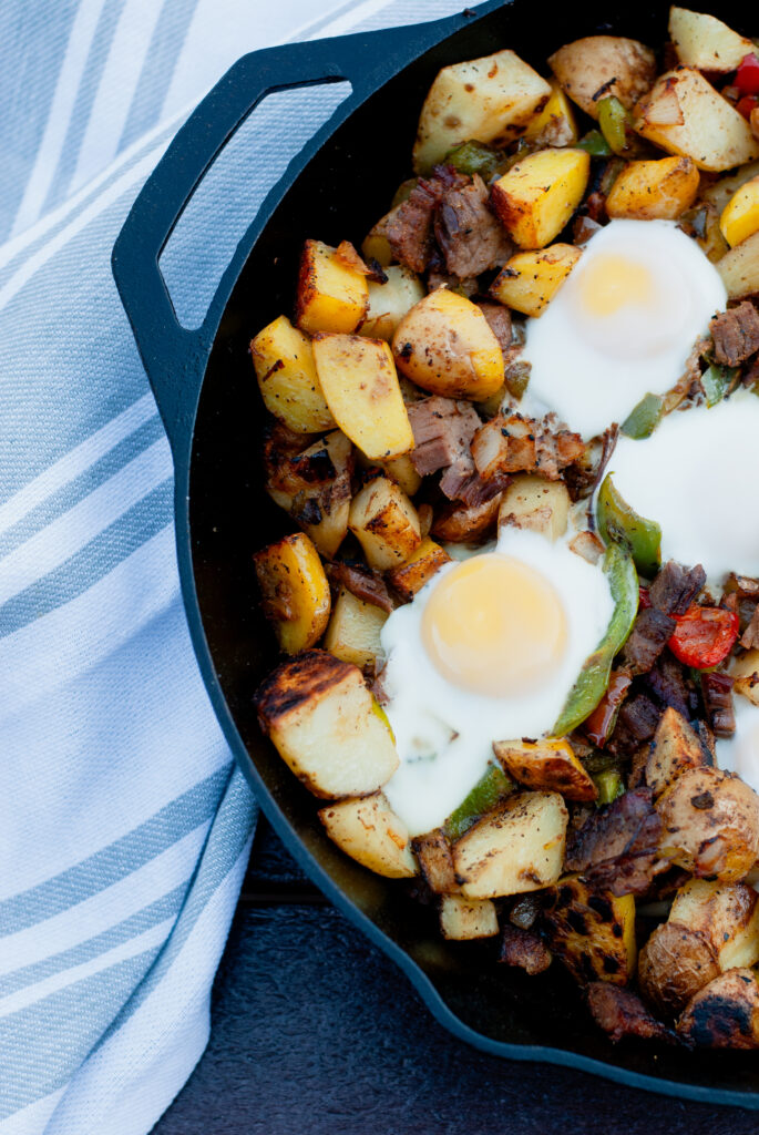 Hash in a cast iron skillet with eggs and peppers for a Christmas Morning Breakfast Recipe 