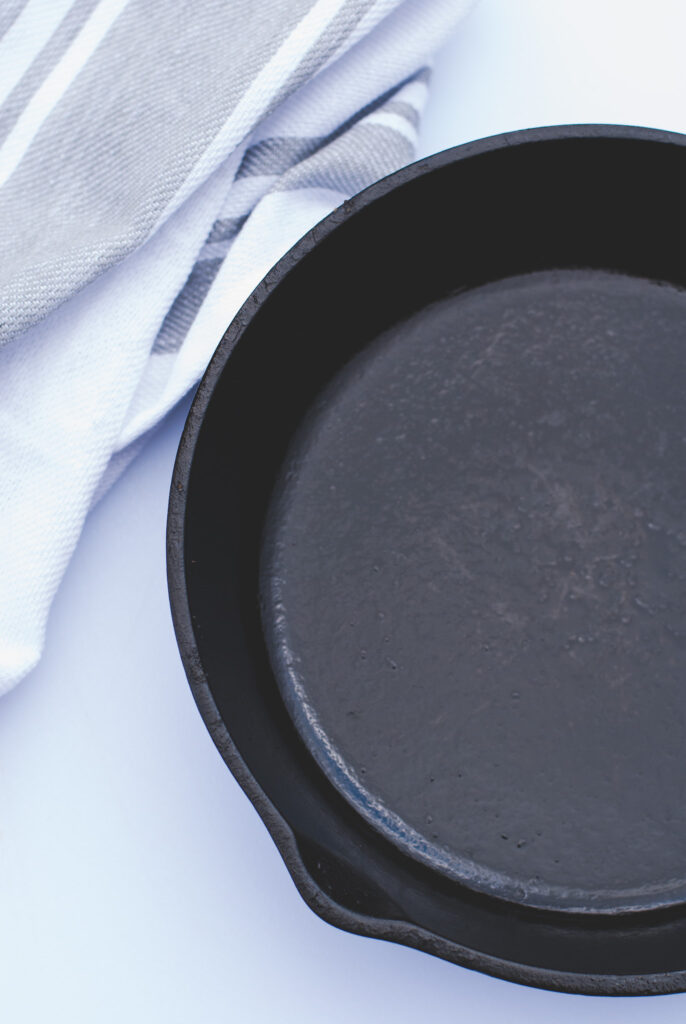 Best cast iron skillet on kitchen counter with hand gray hand towel. 