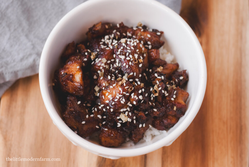 Honey Wine Chicken in white bowl on with gray towel in background. 