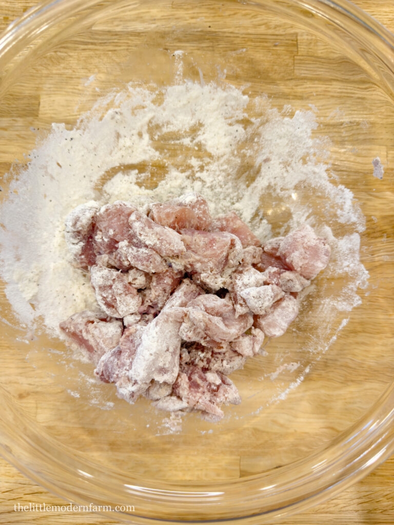 Chicken pieces in a bowl with flour 