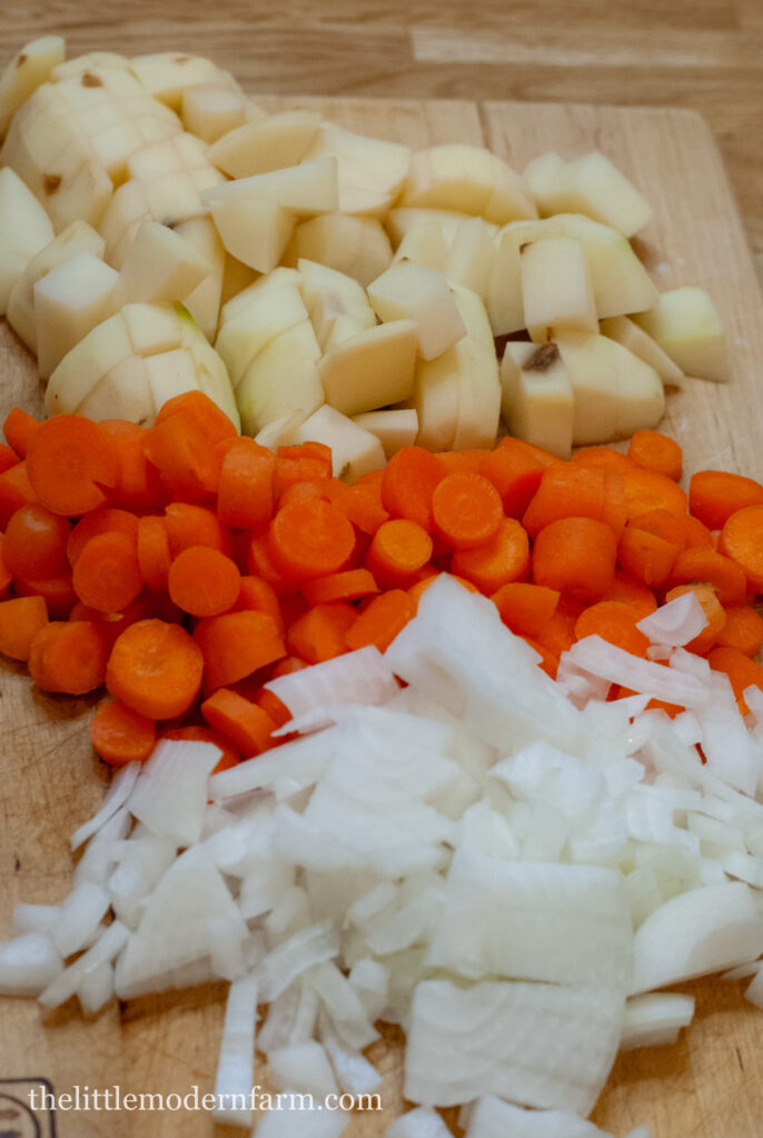 diced potatoes, carrots and onions on a cutting board 