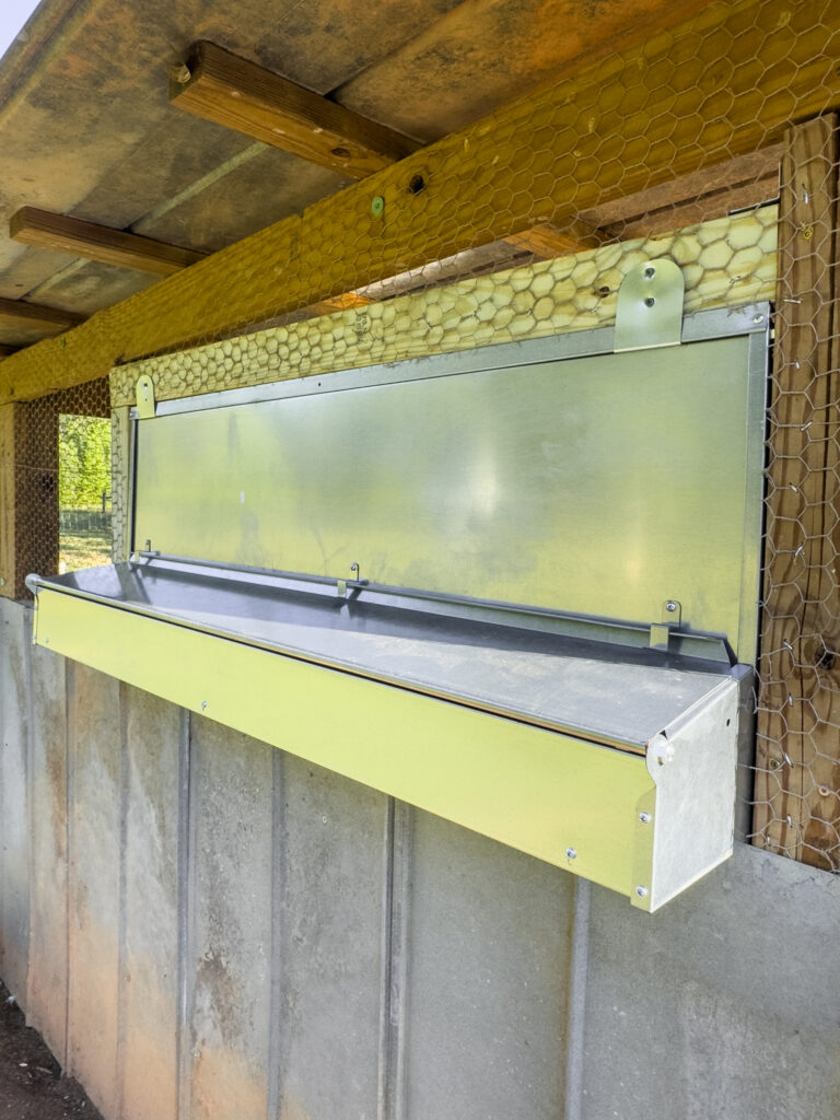 Metal nesting box with exterior egg collection chamber in a coop 