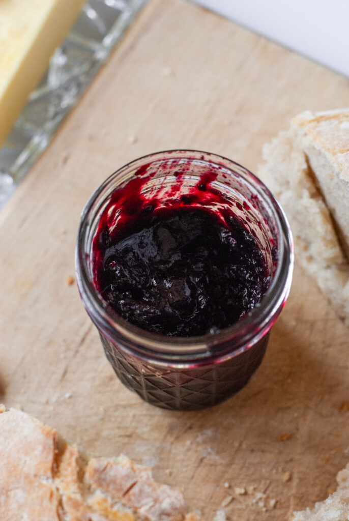 Blueberry jalapeño jam in a jar on a counter top 