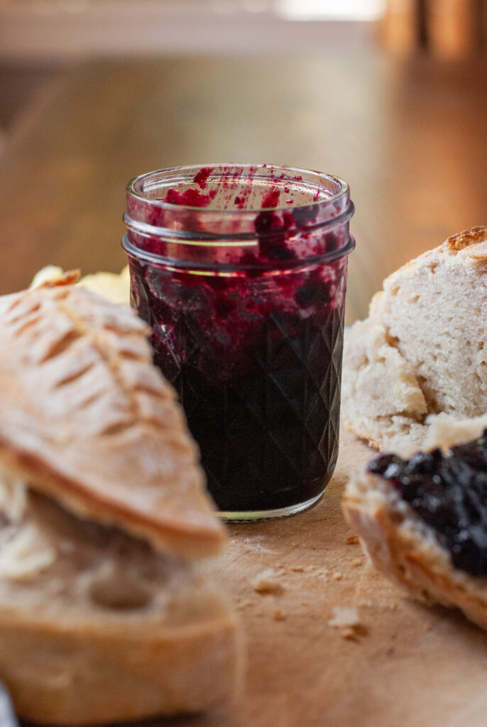 blueberry jalapeño jam in a  jar with bread 