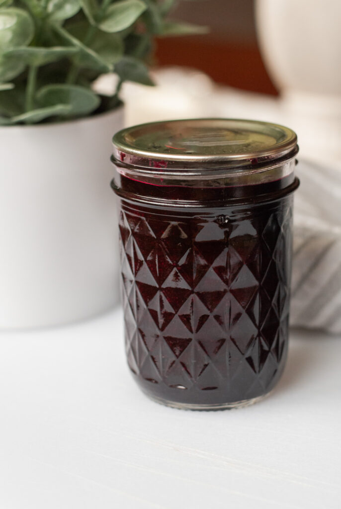 Blueberry jam in a mason jar on a counter top 