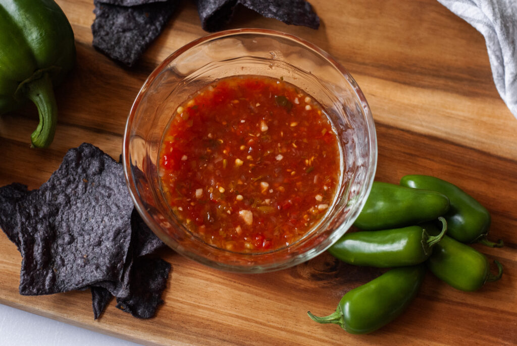 jalapeño salsa in a glass bowl on a counter top. 