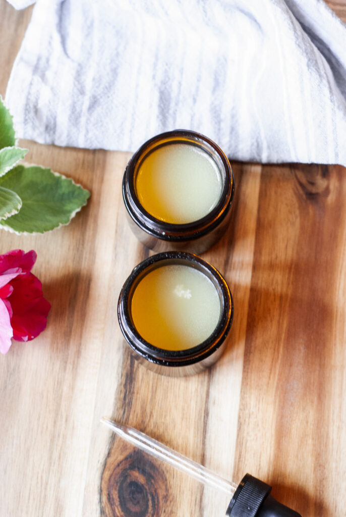 Two amber jars with shea butter moisturizer on a wooden surface 