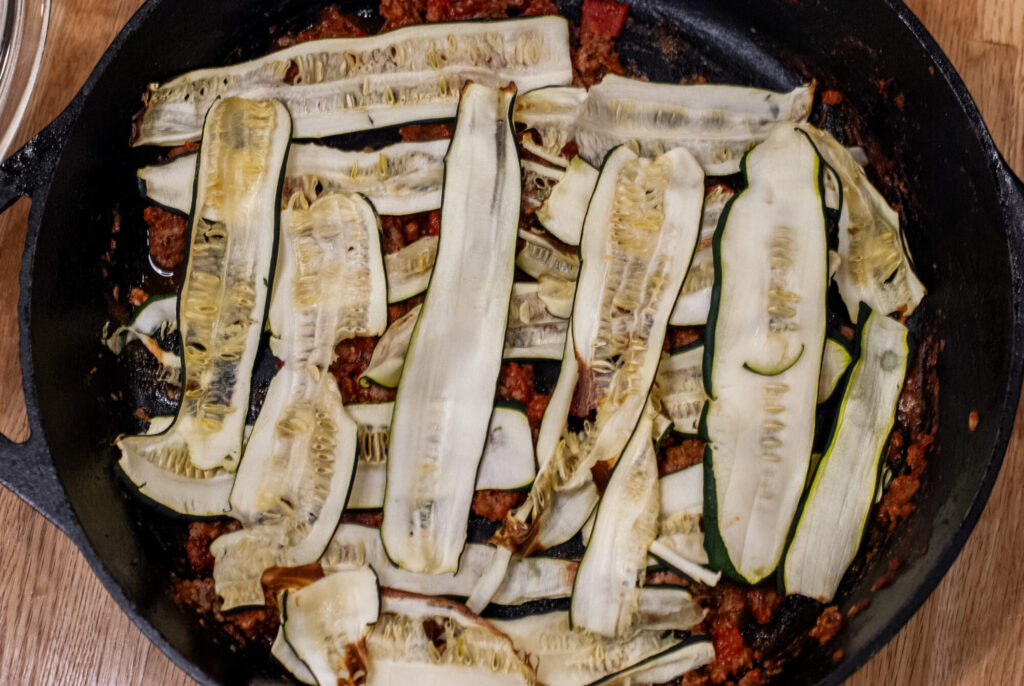 Layering vegetables in lasagna in a cast iron skillet 