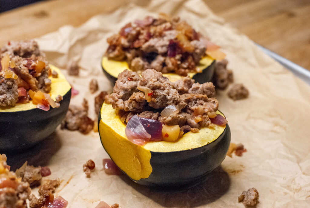 Stuffed acorn squash on a pan with parchment 