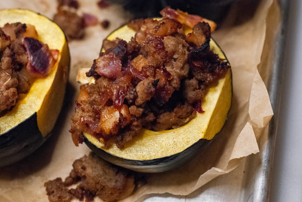 sausage stuffed acorn squash on parchment paper 