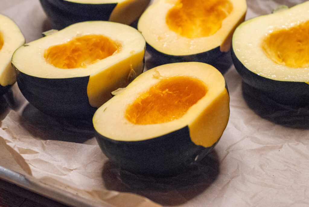 Acorn squash on a sheet pan with seeds removed 