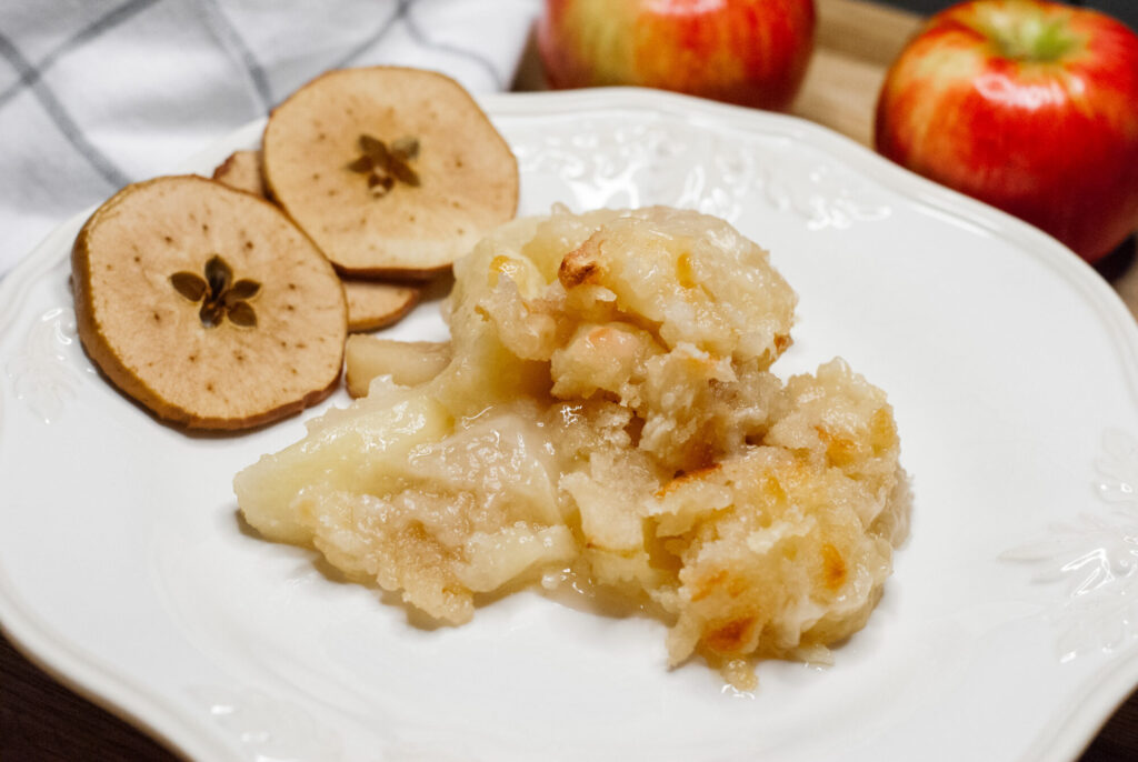 apple cheese casserole on a plate with dried apples. 