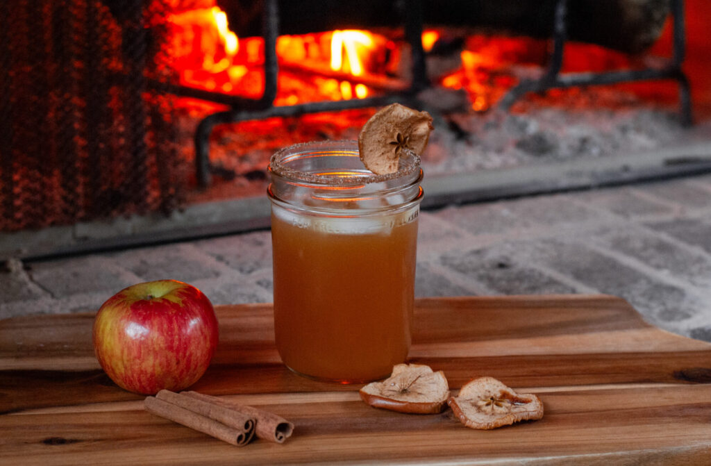 cocktail with apples in front of fire 