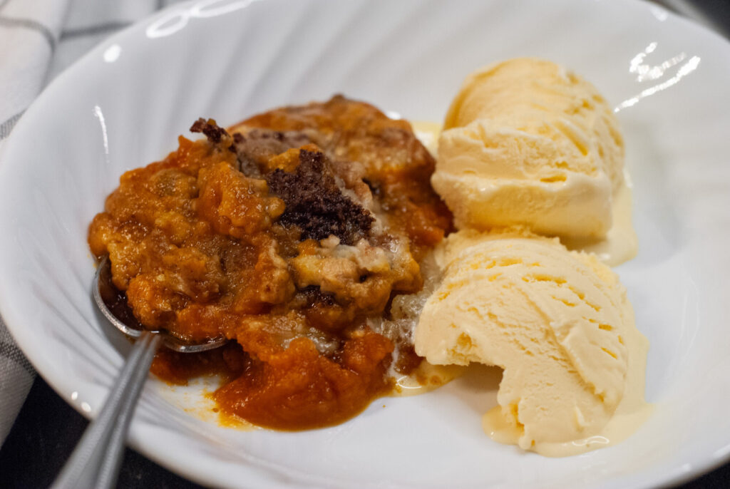 cobbler on a plate with vanilla ice cream. 