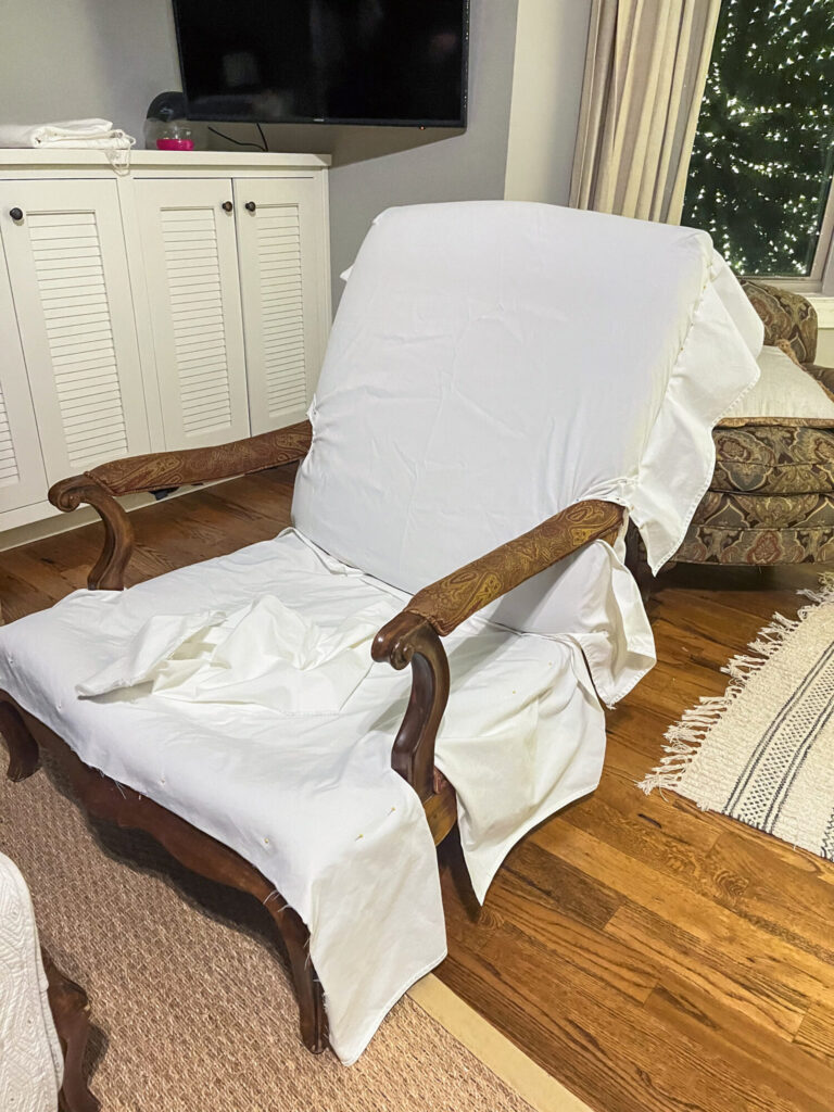 Pin fitting white slipcover on bergere  chair 