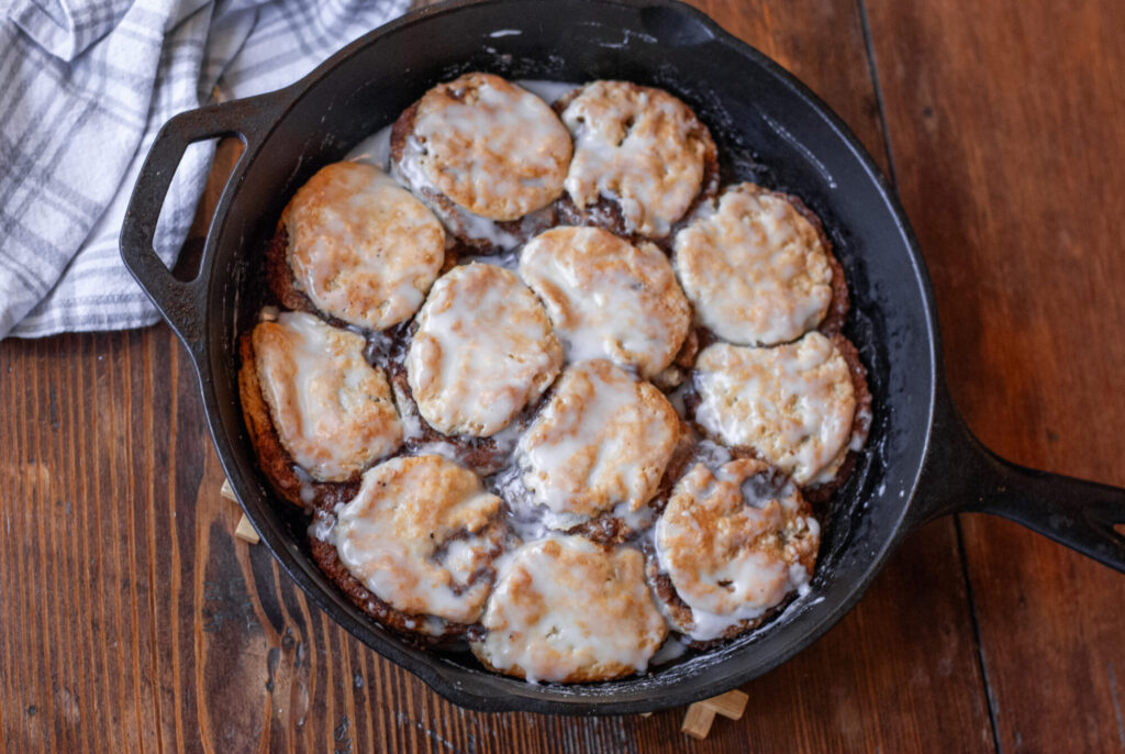 Cinnamon Roll Biscuits in cast iron skillet with and towel 