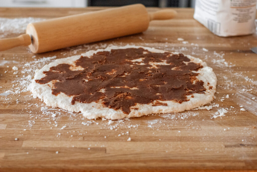 Biscuit dough with cinnamon sugar and rolling pin. 