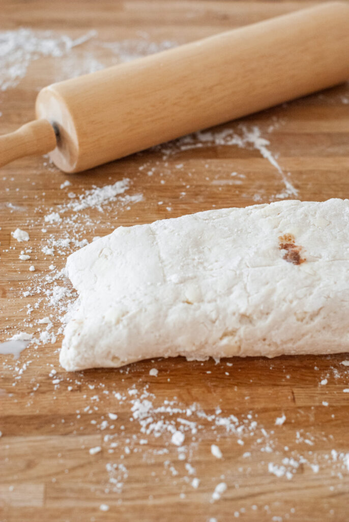 Biscuit dough on floured surface with rolling pin 