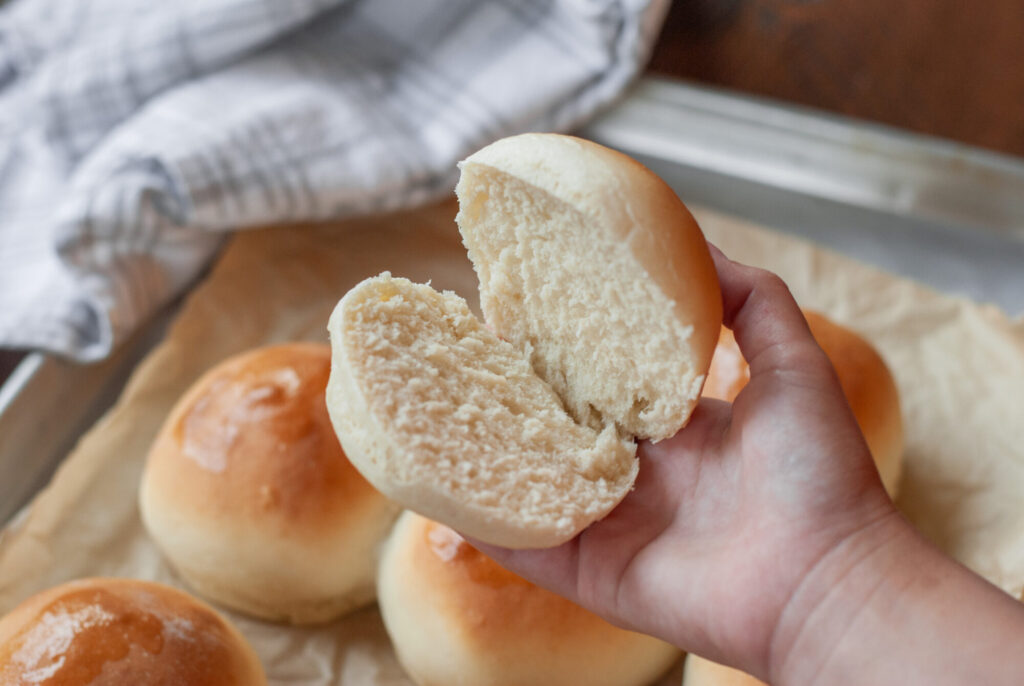 sliced hamburger bun in someone's hand