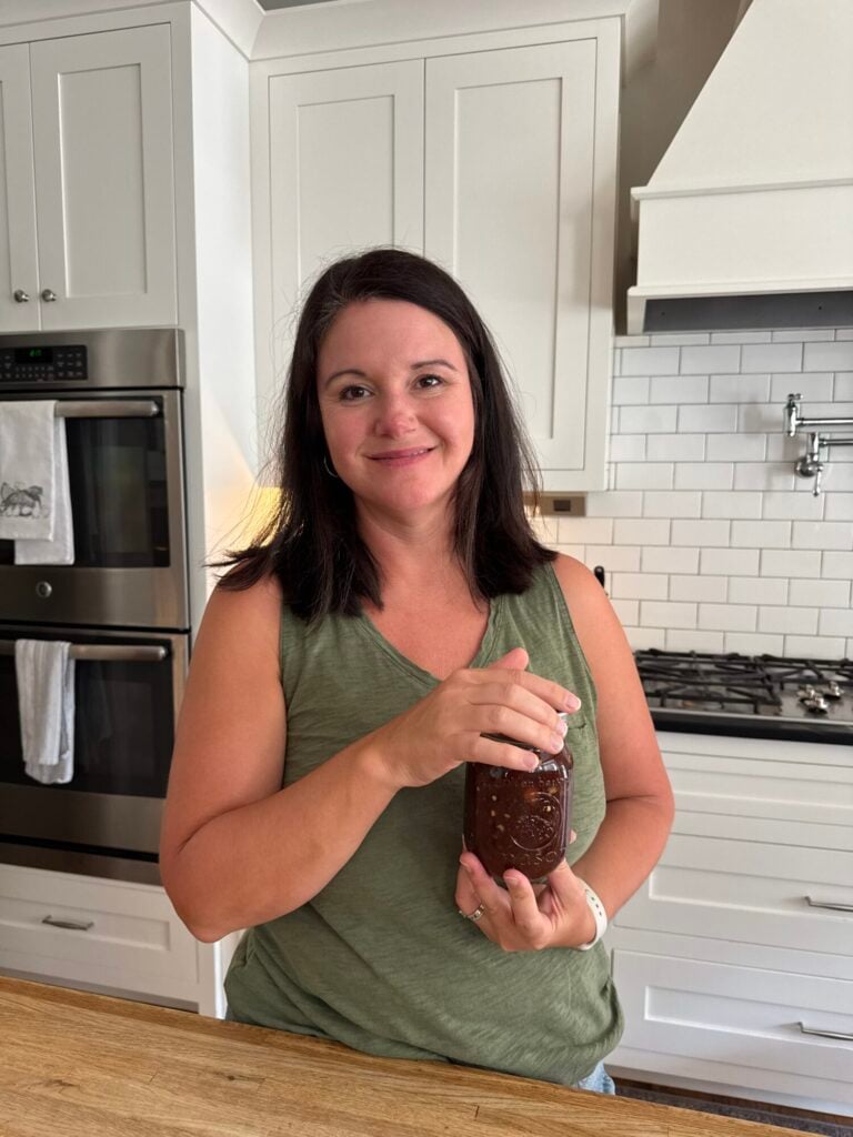 girl with brown hair holding a jar of preserves